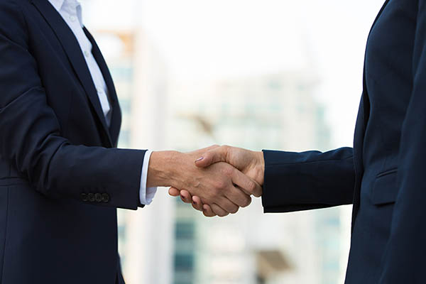 Female colleagues greeting each other in city. Closeup of business women shaking hands outside. Welcome gesture concept